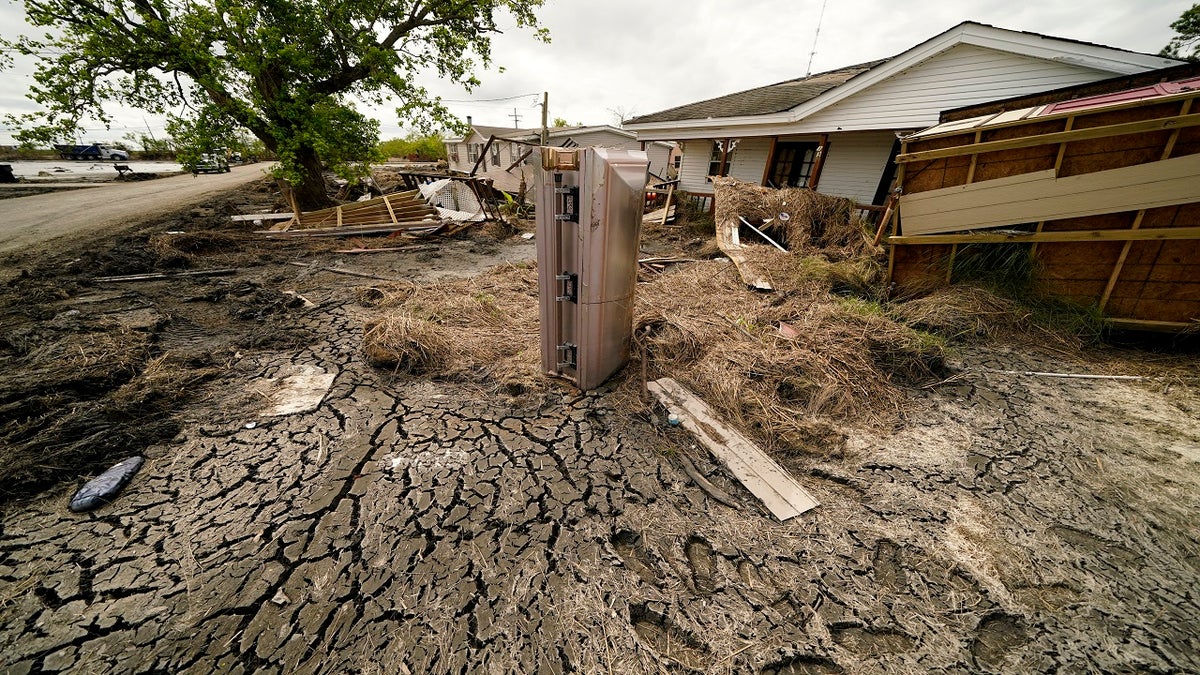 A casket that floated from its tombs during flooding from Hurricane Ida sits in a lawn of a destroyed home in Ironton, Louisiana, on Sept. 27.