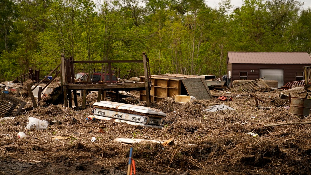 A displaced casket that floated from a cemetery during flooding from Hurricane Ida sits among displaced marsh grass and ruin in Ironton, La., on Sept. 27.