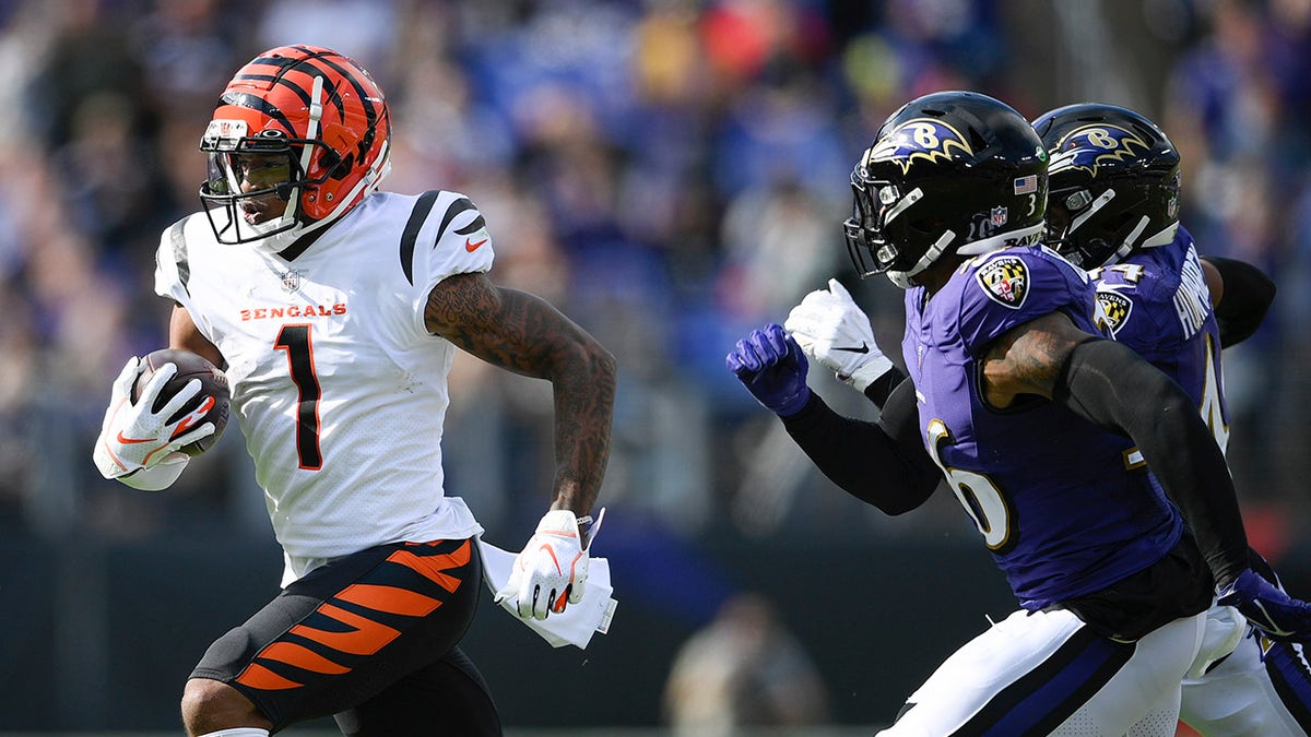Cincinnati Bengals wide receiver Ja'Marr Chase (1) runs with the ball against Baltimore Ravens safety Chuck Clark (36) and cornerback Marlon Humphrey during the first half of an NFL football game, Sunday, Oct. 24, 2021, in Baltimore.