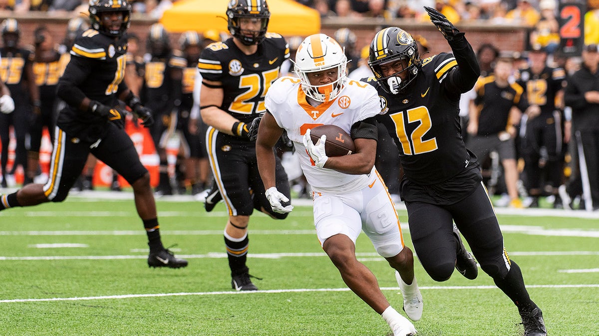 Tennessee running back Jabari Small, center, is chased by Missouri defensive back Shawn Robinson, right, and Blaze Alldredge, left, during the first half of an NCAA college football game Saturday, Oct. 2, 2021, in Columbia, Mo. 