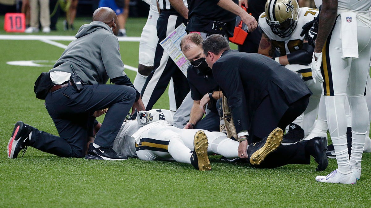 New Orleans Saints quarterback Jameis Winston is tended to after being injured from a horse collar tackle in the first half of an NFL football game against the Tampa Bay Buccaneers in New Orleans, Sunday, Oct. 31, 2021.