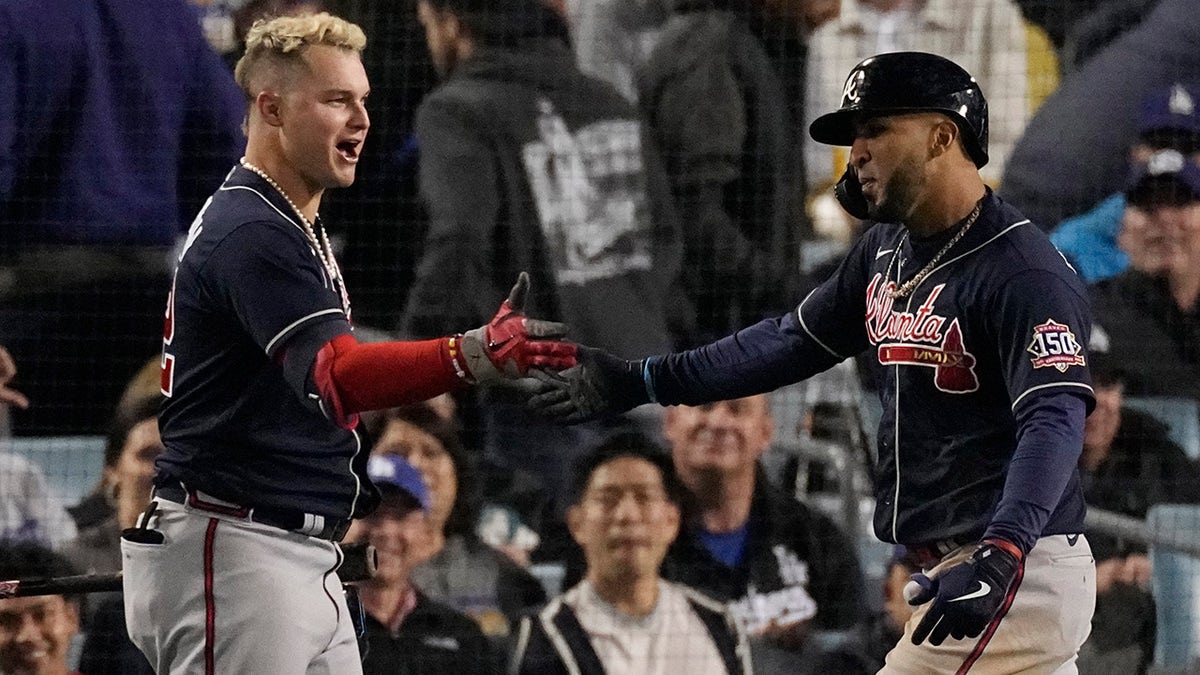 Atlanta Braves' Eddie Rosario, right, is congratulated by Atlanta Braves' Joc Pederson after hitting a two-run home run in the ninth inning against the Los Angeles Dodgers in Game 4 of baseball's National League Championship Series Wednesday, Oct. 20, 2021, in Los Angeles.