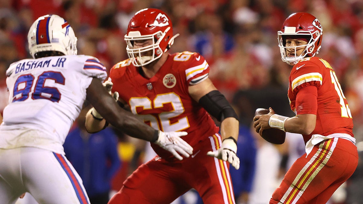 Joe Thuney #62 blocks as Patrick Mahomes #15 of the Kansas City Chiefs looks to pass the ball under pressure from Boogie Basham #96 of the Buffalo Bills during the first half of a game  at Arrowhead Stadium on October 10, 2021, in Kansas City, Missouri.