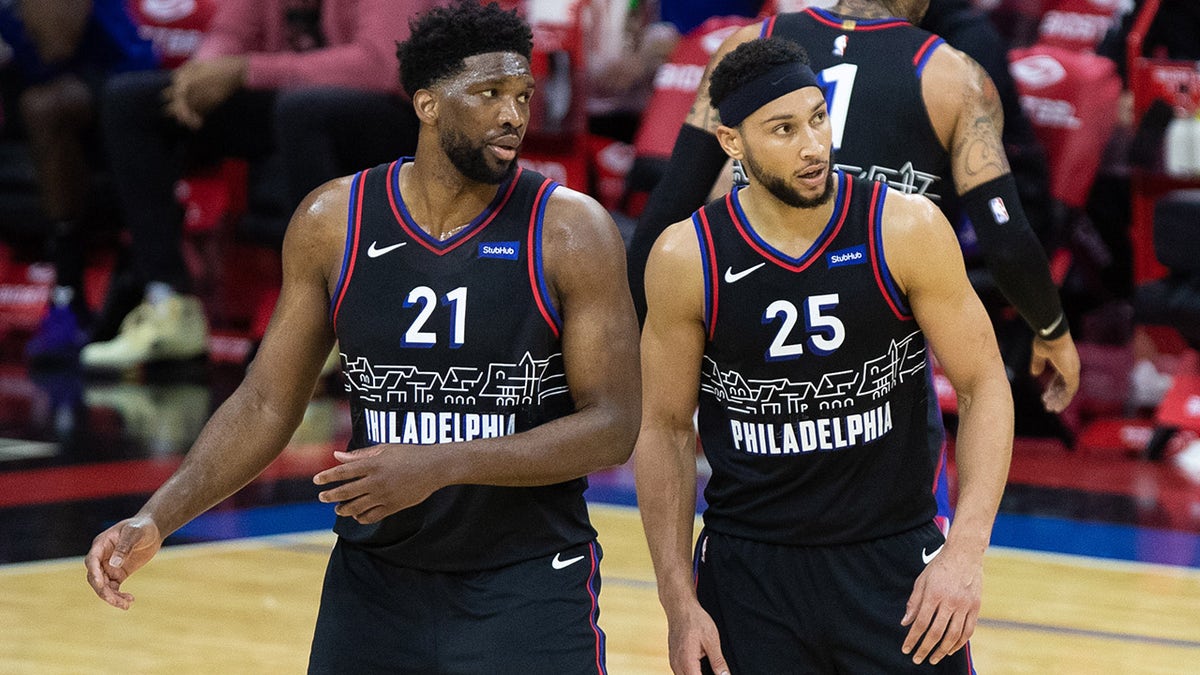 Feb 27, 2021; Philadelphia, Pennsylvania, USA; Philadelphia 76ers guard Ben Simmons (25) and center Joel Embiid (21) look on during the third quarter against the Cleveland Cavaliers at Wells Fargo Center.