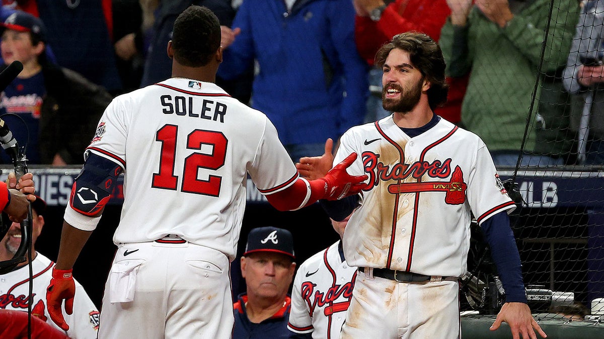 Jorge Soler ?of the Atlanta Braves is congratulated by Dansby Swanson after they hit back-to-back solo home runs against the Houston Astros during the seventh inning in Game Four of the World Series at Truist Park on Oct. 30, 2021, in Atlanta, Georgia.