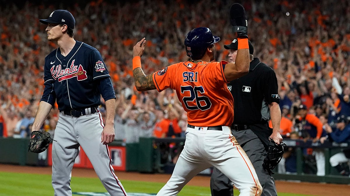 Houston Astros' Jose Siri celebrates past Atlanta Braves starting pitcher Max Fried on a throwing error during the second inning in Game 2 of baseball's World Series between the Houston Astros and the Atlanta Braves Wednesday, Oct. 27, 2021, in Houston.