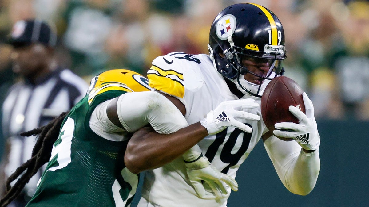 Pittsburgh Steelers' JuJu Smith-Schuster catches a pass with Green Bay Packers' De'Vondre Campbell defending during the second half of an NFL football game Sunday, Oct. 3, 2021, in Green Bay, Wis.