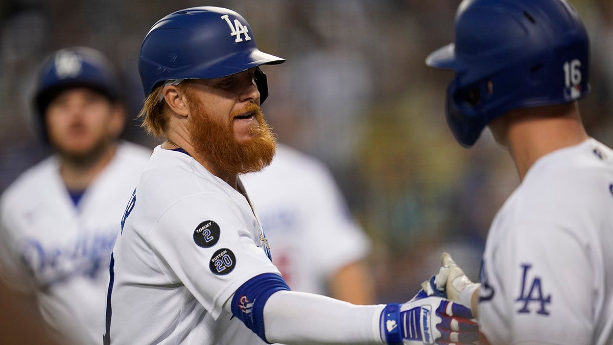 Los Angeles Dodgers' Justin Turner celebrates with Will Smith (16) after hitting a home run during the first inning of a baseball game against the Milwaukee Brewers Saturday, Oct. 2, 2021, in Los Angeles. Trea Turner and Marx Muncy also scored.