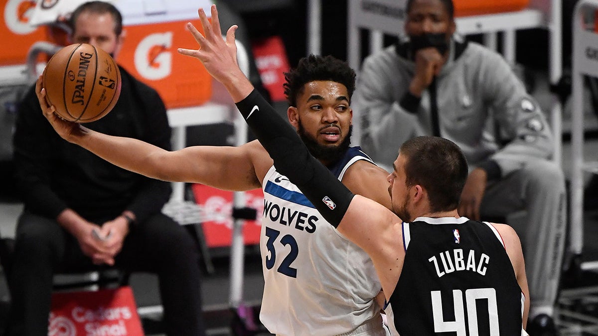 Karl-Anthony Towns (32) of the Minnesota Timberwolves looks to pass the ball as he is defended by Ivica Zubac (40) of the Los Angeles Clippers during the first half of a game at Staples Center April 18, 2021 in Los Angeles, California.