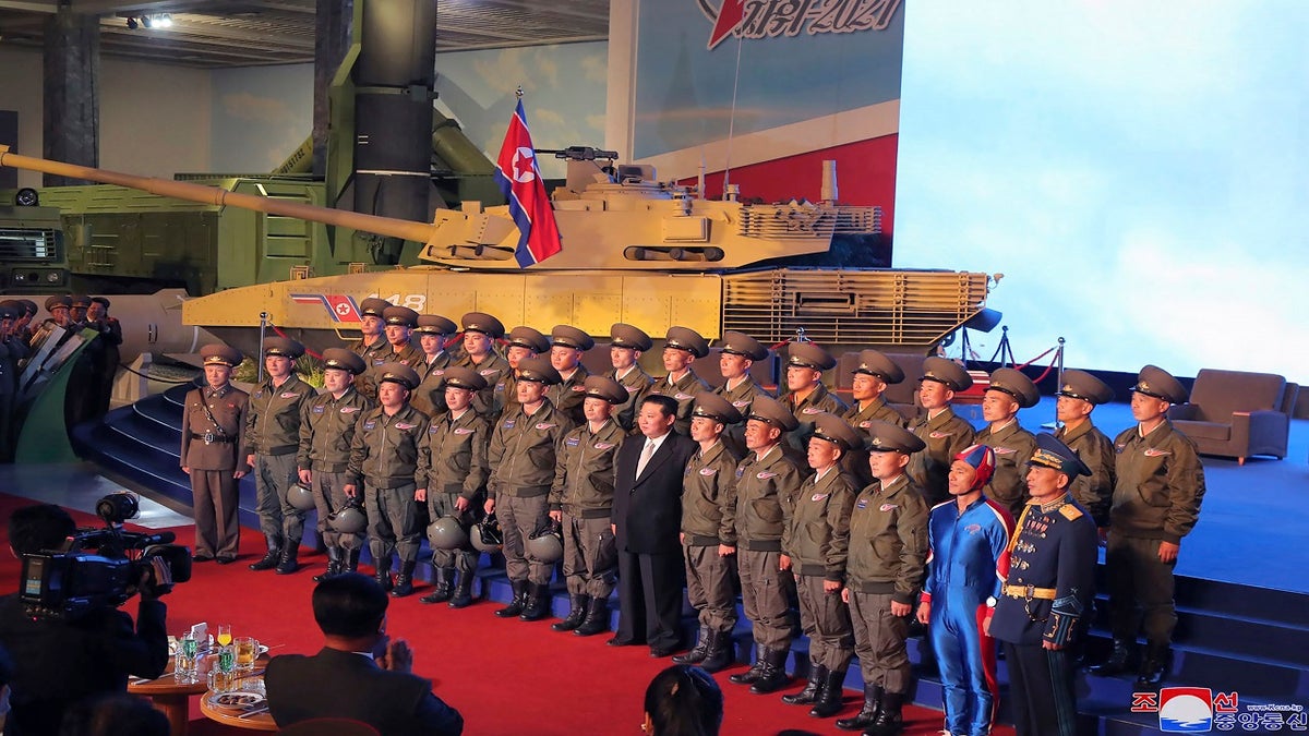 North Korean leader Kim Jong Un, center, poses for a group photo with fighter pilots who made the demonstration flight at the opening of an exhibition of weapons systems in Pyongyang, North Korea, on Monday. (Korean Central News Agency/Korea News Service via AP)