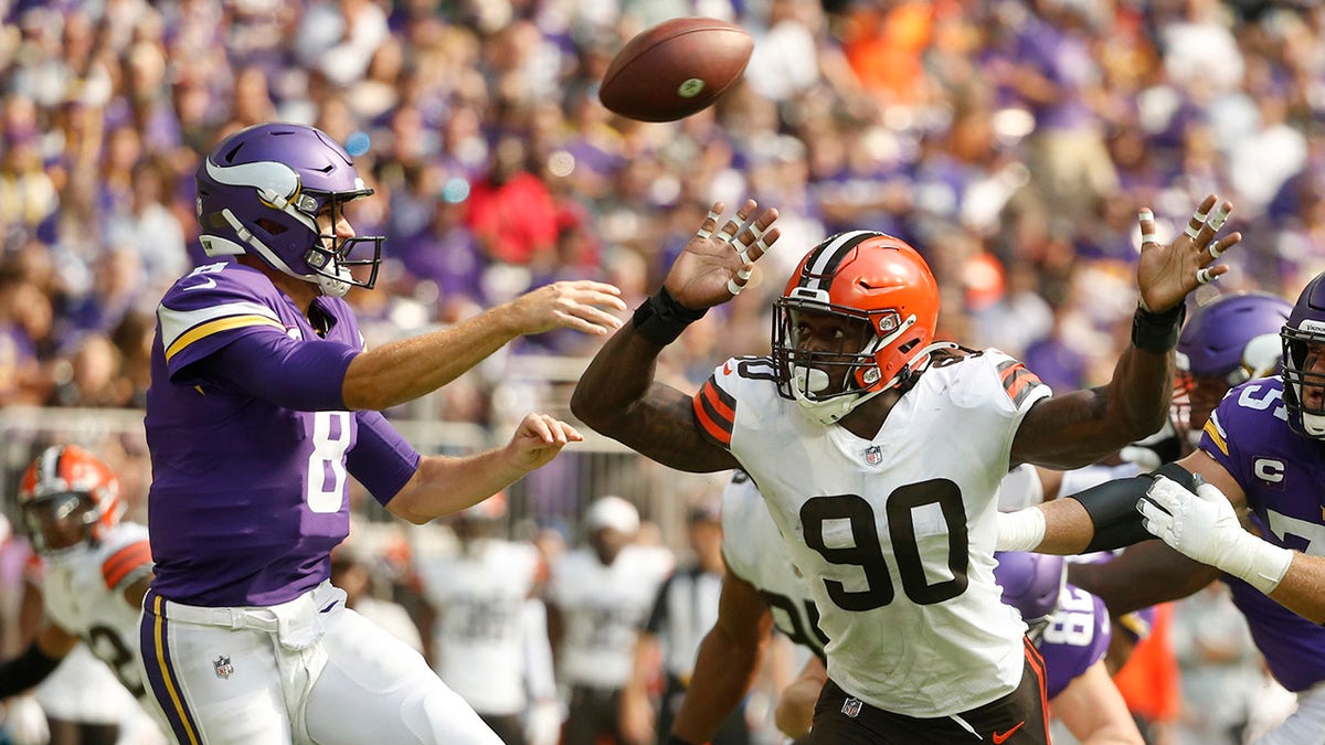 Cleveland Browns defensive end Jadeveon Clowney (90) pressures Minnesota Vikings quarterback Kirk Cousins (8) as he throws a pass during the first half of an NFL football game, Sunday, Oct. 3, 2021, in Minneapolis.