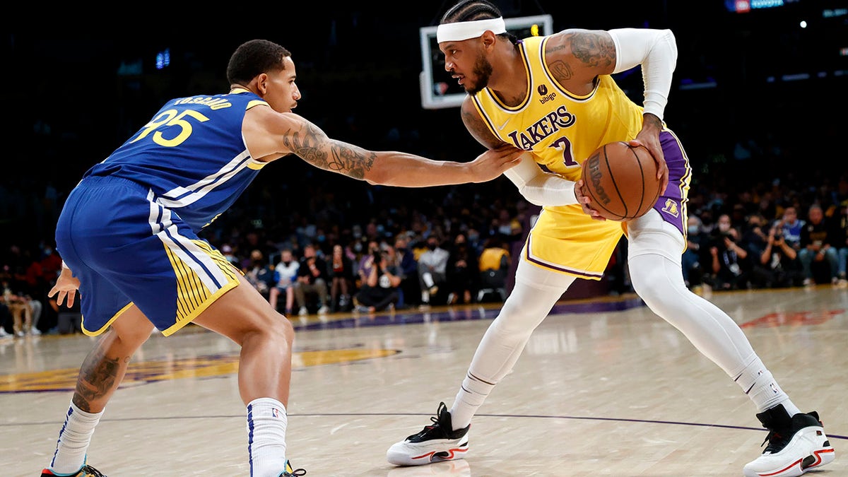 Los Angeles Lakers forward Carmelo Anthony (7) is defended by Golden State Warriors forward Juan Toscano-Anderson (95) during the first half of an NBA basketball game in Los Angeles, Tuesday, Oct. 19, 2021.