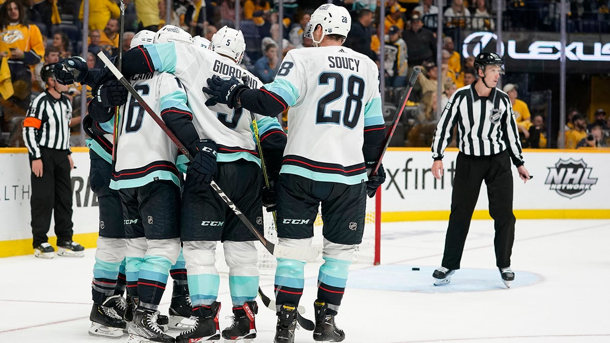 Seattle Kraken celebrate after scoring an empty-net goal against the Nashville Predators in the third period of an NHL hockey game Thursday, Oct. 14, 2021, in Nashville, Tenn. The Kraken won 4-3 for their first franchise win.