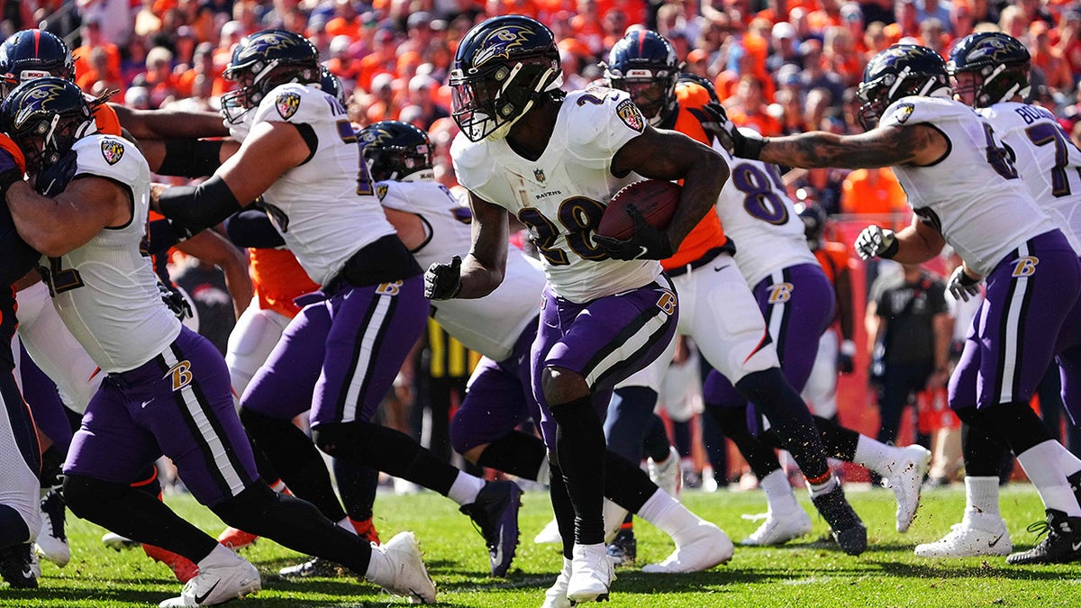Oct 3, 2021; Denver, Colorado, USA; Baltimore Ravens running back Latavius Murray (28) carries the ball in the first quarter against the Denver Broncos at Empower Field at Mile High.