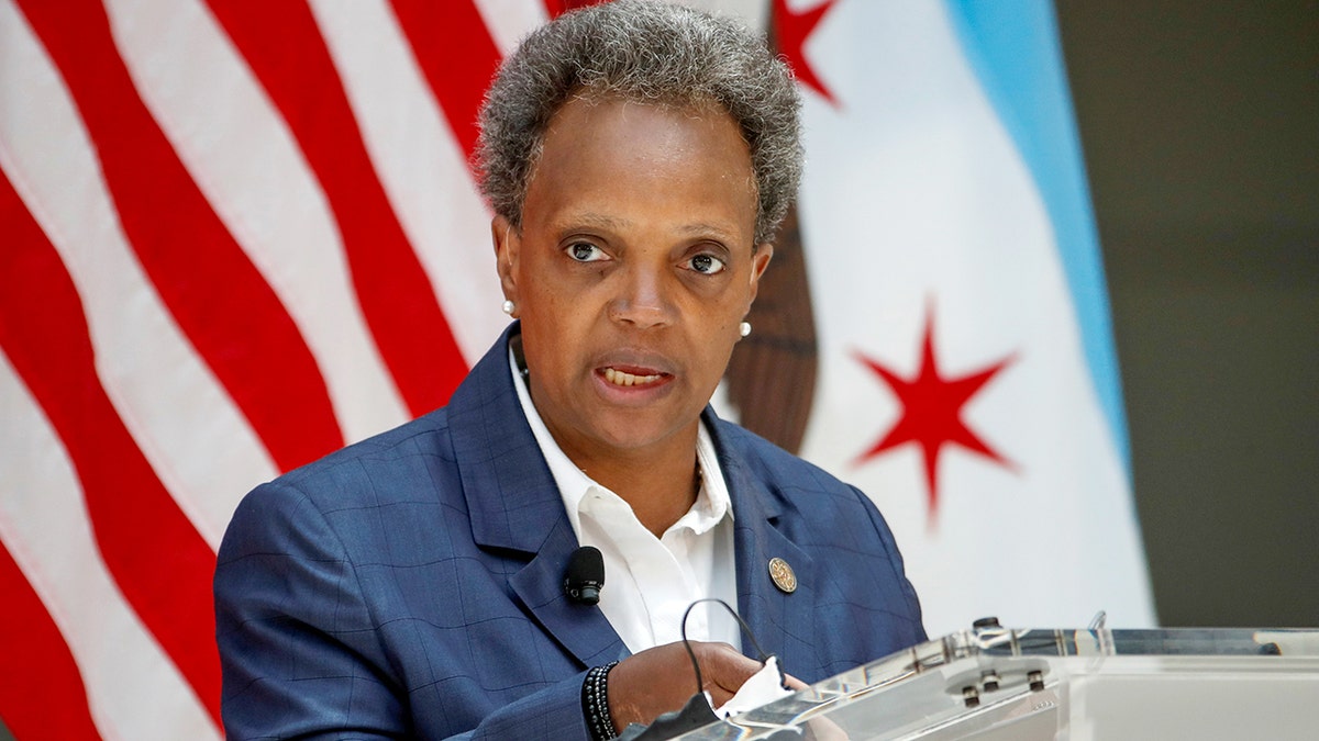 Photo showing Chicago Mayor Lori Lightfoot delivering reamrks in 2020 at a podium