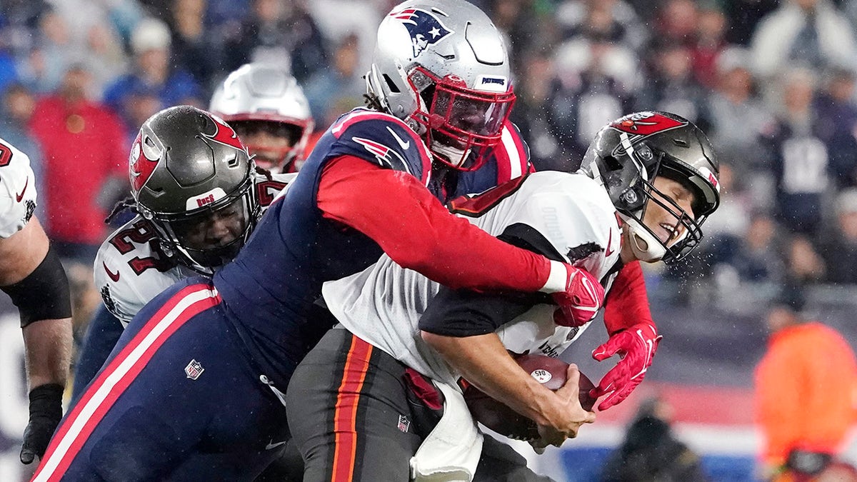 Tampa Bay Buccaneers quarterback Tom Brady, right, is sacked by New England Patriots outside linebacker Matt Judon, left, during the first half of an NFL football game, Sunday, Oct. 3, 2021, in Foxborough, Mass. ()