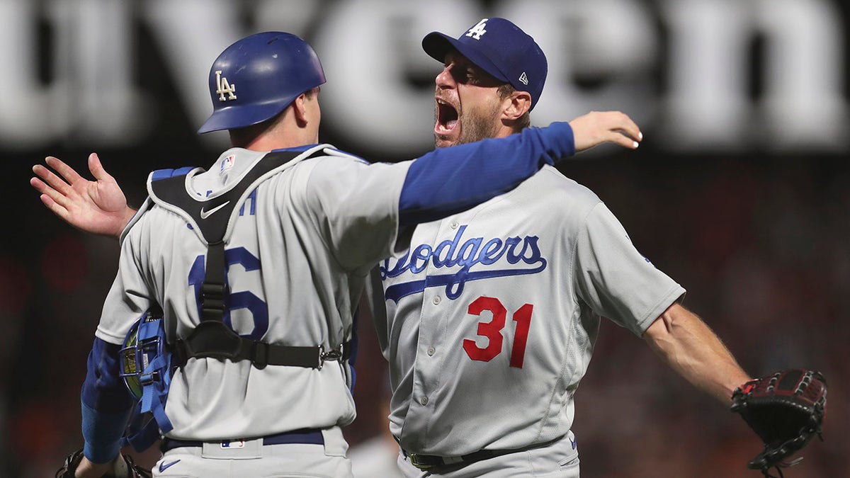 Los Angeles Dodgers catcher Will Smith, left, celebrates with pitcher Max Scherzer (31) after defeating the San Francisco Giants in Game 5 of a baseball National League Division Series Thursday, Oct. 14, 2021, in San Francisco.