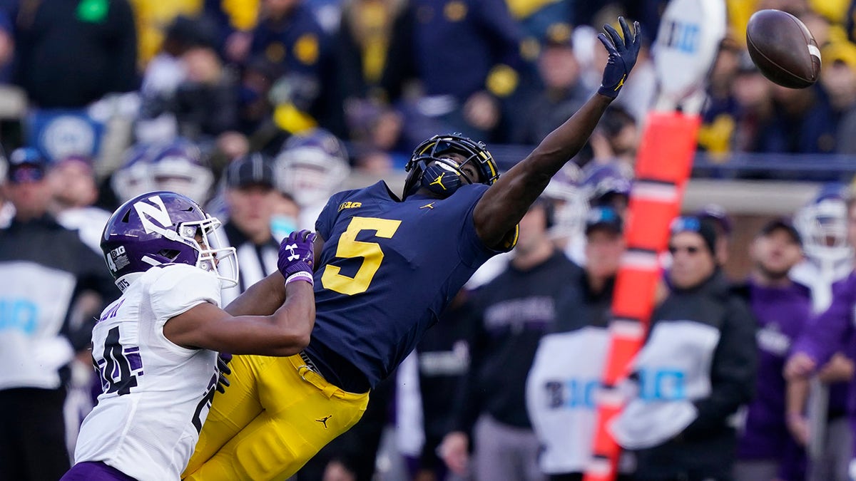 Michigan wide receiver Mike Sainristil (5), defended by Northwestern defensive back Rod Heard II (24), stretches but is unable to catch a pass during the second half of a game Saturday, Oct. 23, 2021, in Ann Arbor, Mich.