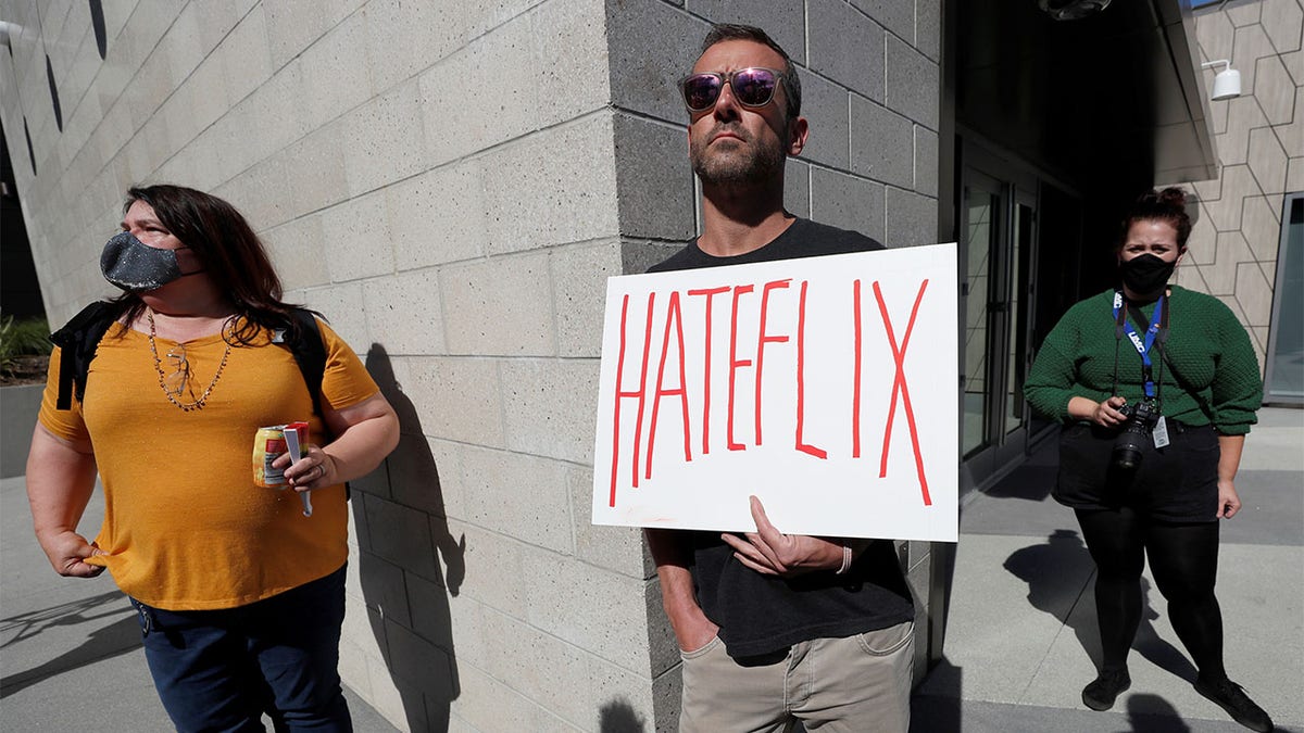 Dave Briggs holds a placard as he attends a rally in support of the Netflix transgender employee walkout "Stand Up in Solidarity" to protest the streaming of comedian Dave Chappelle?s new comedy special, in Los Angeles, California, U.S. October 20 2021. REUTERS/Mario Anzuoni