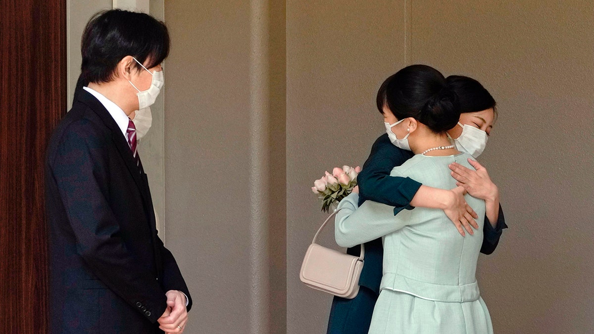 Japan's Princess Mako, right, hugs her sister Princess Kako, watched by her parents Crown Prince Akishino and Crown Princess Kiko, before leaving her home in Akasaka Estate in Tokyo on Tuesday.