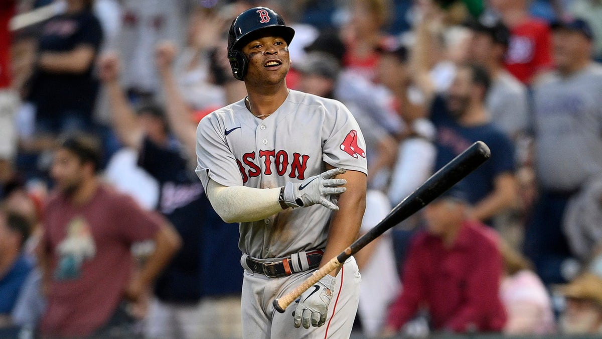 Boston Red Sox' Rafael Devers tosses his bat and celebrates his two-run home run during the ninth inning of a game against the Washington Nationals, Sunday, Oct. 3, 2021, in Washington. The Red Sox won 7-5.