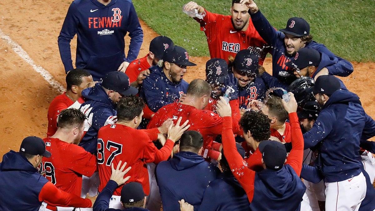 Boston Red Sox Christian Vazquez is mobbed by teammates after hitting a two-run walk-off home run during the thirteenth inning against the Tampa Bay Rays during Game 3 of a baseball American League Division Series, Sunday, Oct. 10, 2021, in Boston. Boston won 6-4.