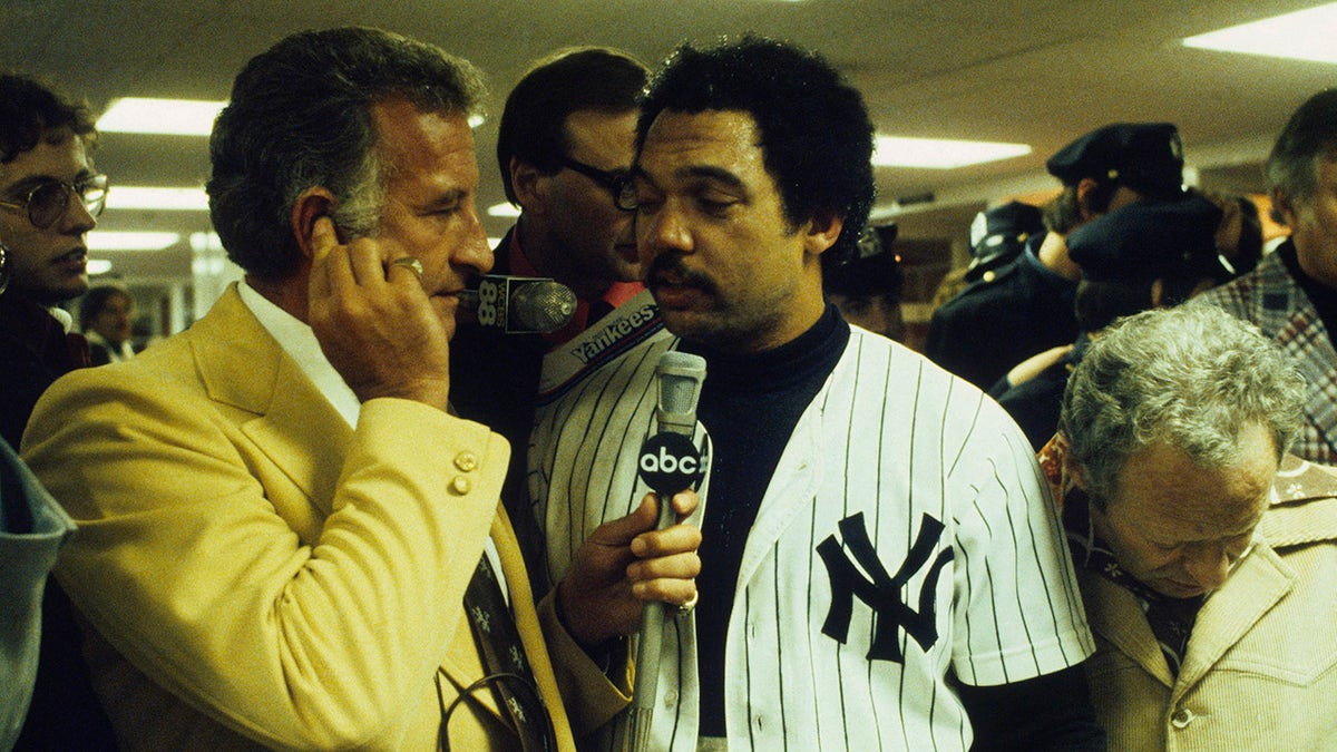 Reggie Jackson #44 of the New York Yankees is interviewed by Bob Uecker in the locker after the Yankees won the World Series against the Los Angeles Dodgers on Oct. 18, 1977 at Yankee Stadium in Bronx, New York.