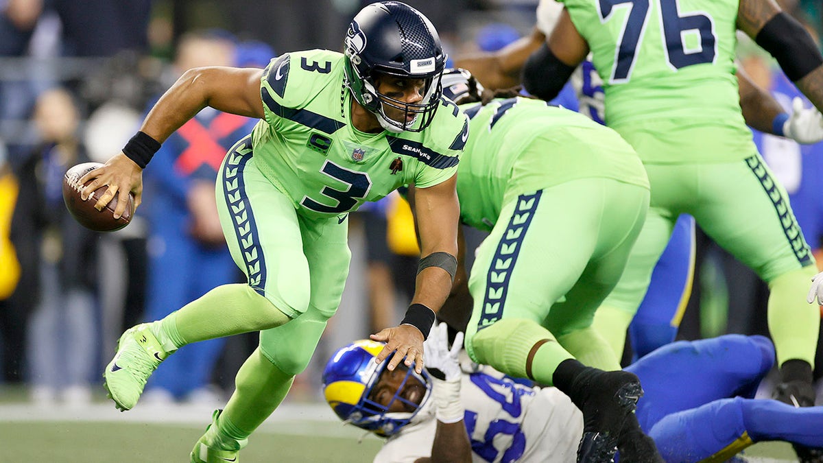 Quarterback Russell Wilson of the Seattle Seahawks scrambles with the ball against the Los Angeles Rams in the second half at Lumen Field on Oct. 07, 2021, in Seattle, Washington.