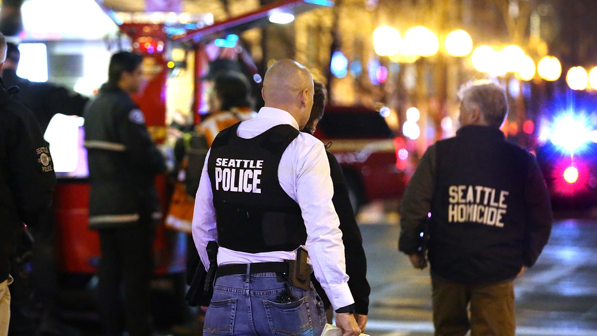 Photo shows Seattle police officers on the street reviewing a crime scene in 2020