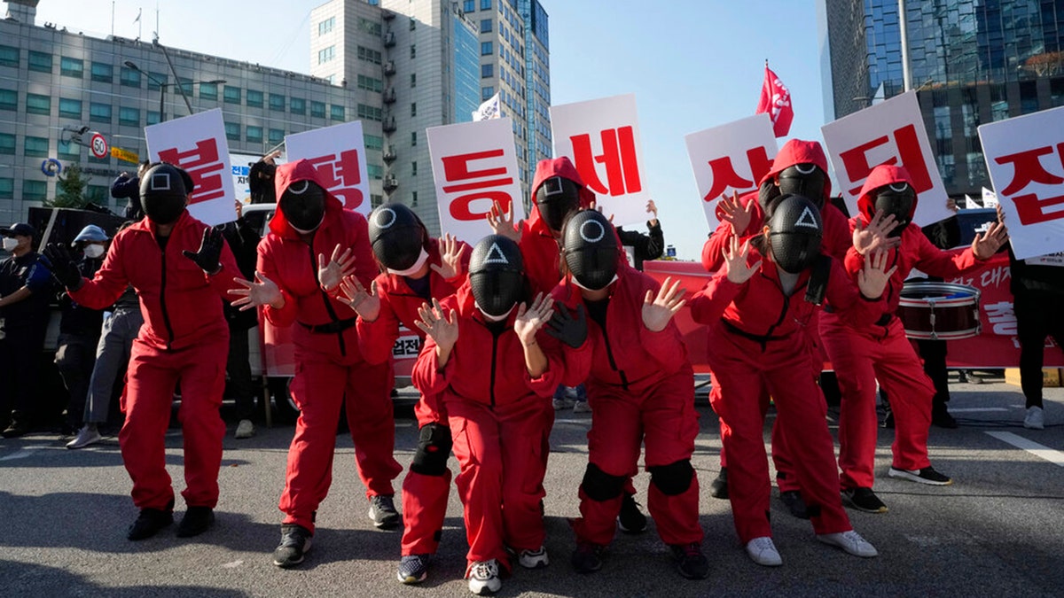 Members of the South Korean Confederation of Trade Unions wearing masks and costumes inspired by the Netflix original Korean series "Squid Game" perform during a rally demanding job security in Seoul, South Korea, Wednesday, Oct. 20, 2021. (AP Photo/Ahn Young-joon)