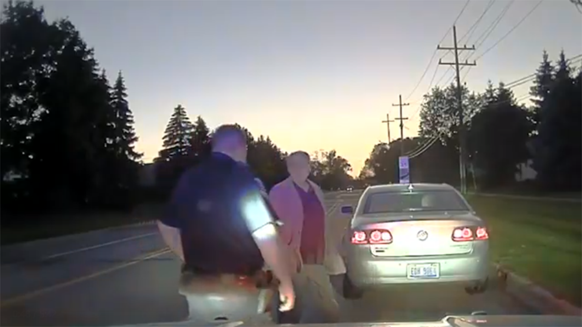 An officer pulling over a man for speeding. 