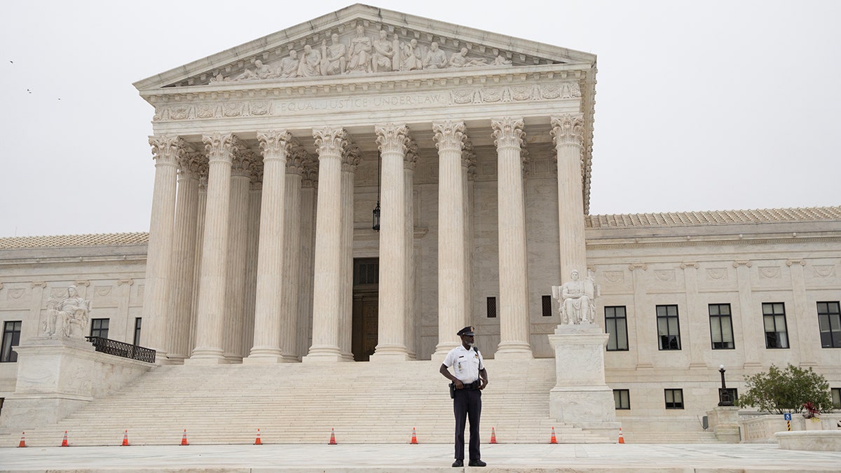 A police officer patrols in front of the U.S. Supreme Court in Washington on Oct. 12, 2021.