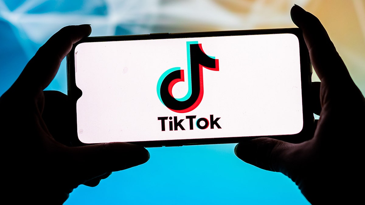 TikTok logo on a phone in two hands