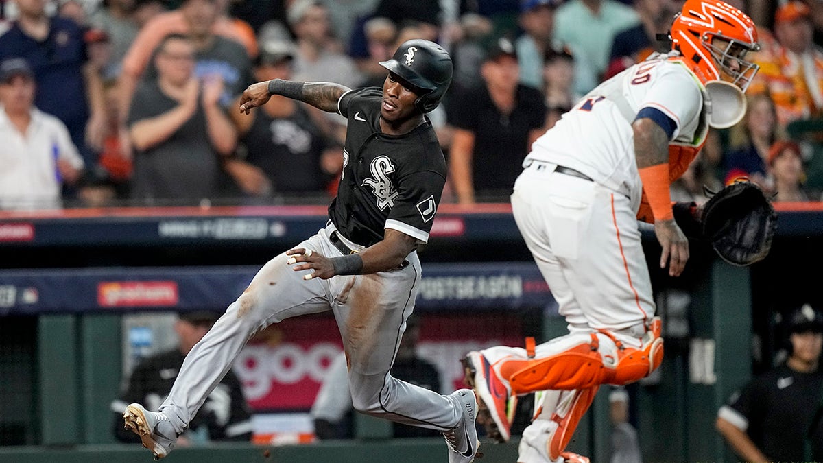 The Chicago White Sox' Tim Anderson, left, slides into home plate while scoring on an RBI single by Jose Abreu as Houston Astros catcher Martin Maldonado waits for a relay throw during the eighth inning in Game 1 of an American League Division Series Thursday, Oct. 7, 2021, in Houston.