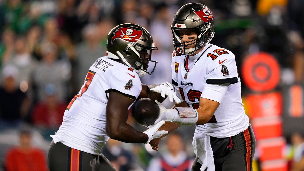 Tampa Bay Buccaneers quarterback Tom Brady (12) hands the ball off to Tampa Bay Buccaneers running back Leonard Fournette (7) during the first half of an NFL football game against the Philadelphia Eagles, Thursday, Oct. 14, 2021, in Philadelphia.