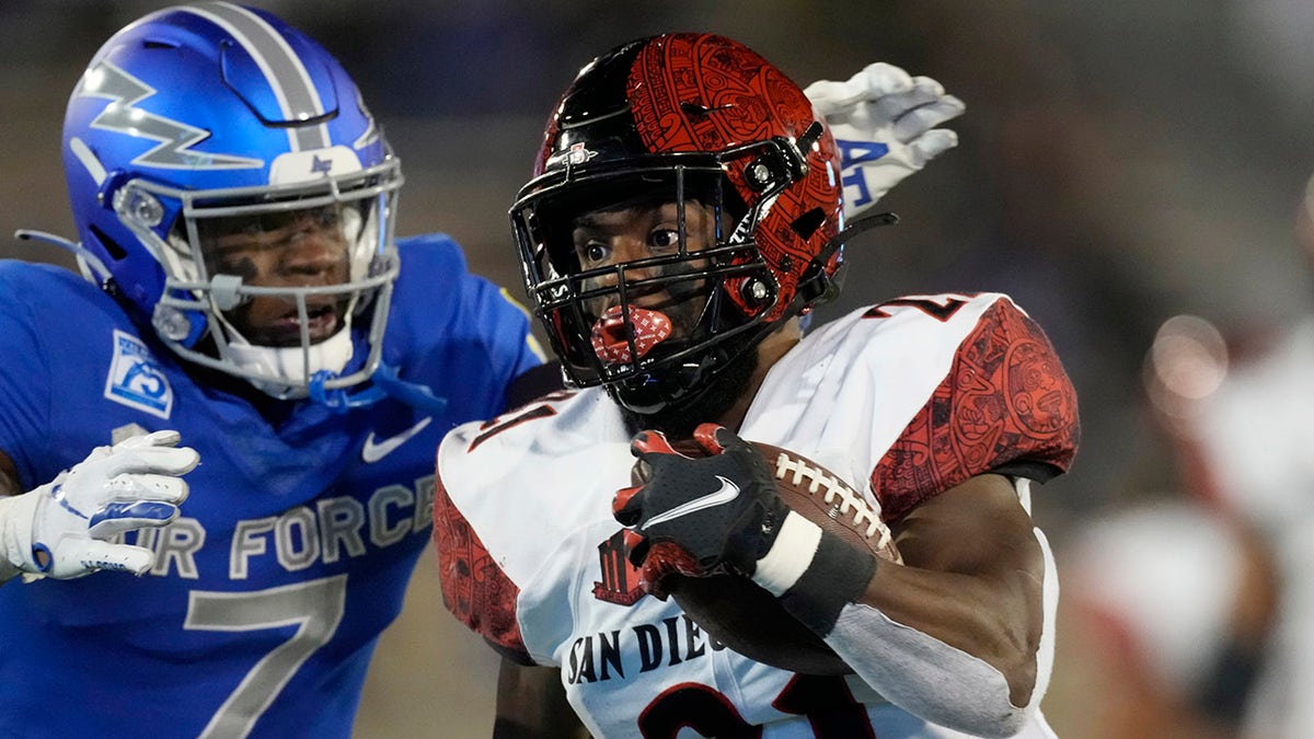 Air Force free safety Trey Taylor, left, reaches to pull down San Diego State running back Chance Bell after a long gain in the second half Saturday, Oct. 23, 2021, at Air Force Academy, Colo.