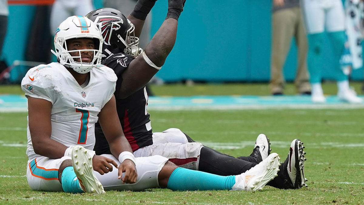 Miami Dolphins quarterback Tua Tagovailoa (1) and Atlanta Falcons defensive tackle Grady Jarrett (97) react after a pass thrown by Tagovailoa was intercepted during the second half Sunday, Oct. 24, 2021, in Miami Gardens, Fla.