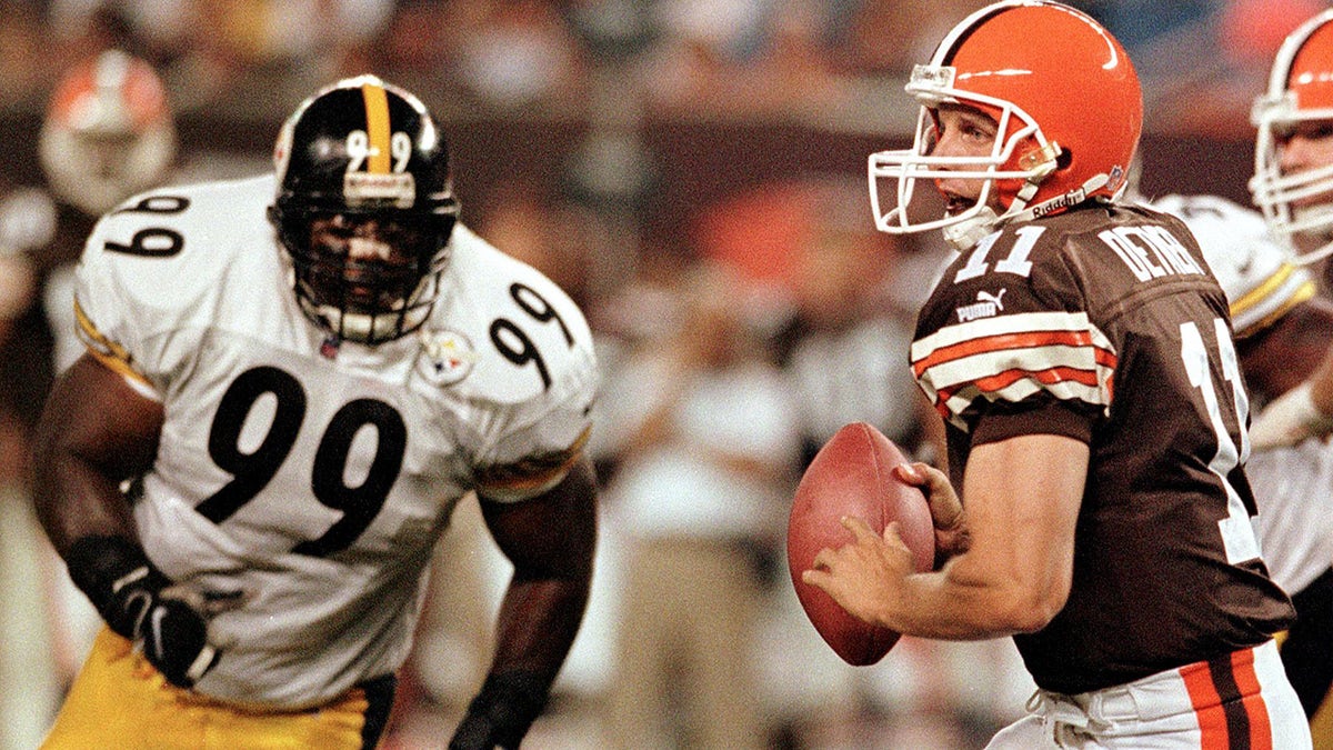 Cleveland Browns quarterback Ty Detmer looks for an open receiver as Pittsburgh Steelers Levon Kirkland closes in during the second quarter on Sept. 12, 1999, at Cleveland Browns Stadium in Ohio. The Browns lost to the Steelers 43-0.