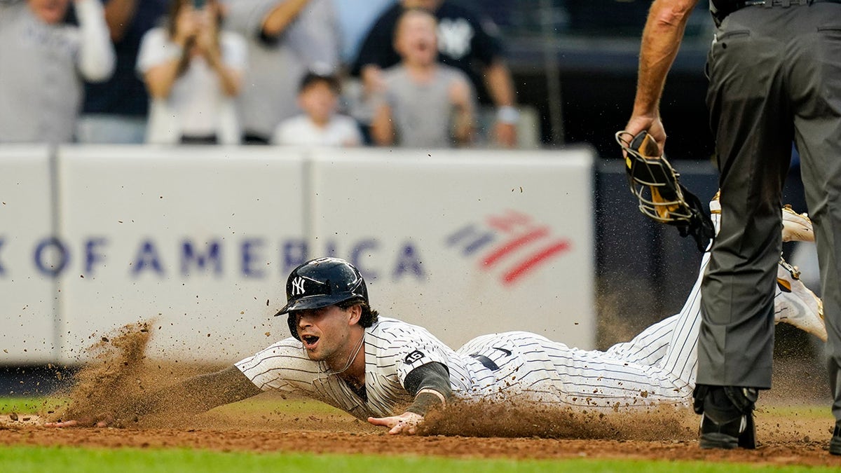 New York Yankees' Tyler Wade scores on a game-winning RBI single by Aaron Judge during the ninth inning of a game against the Tampa Bay Rays Sunday, Oct. 3, 2021, in New York. The Yankees won 1-0.