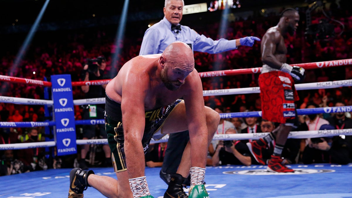 Tyson Fury, of England, gets up after he was knocked down by Deontay Wilder in a heavyweight championship boxing match Saturday, Oct. 9, 2021, in Las Vegas. 