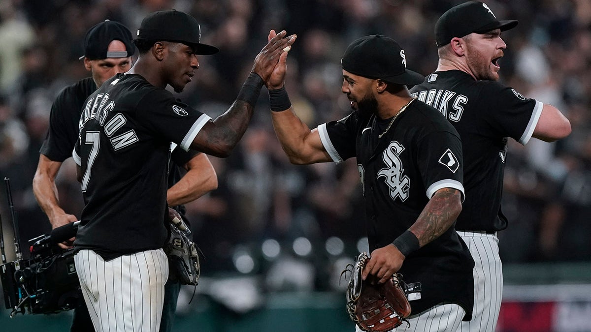 The Chicago White Sox's Tim Anderson (7) and Leury Garcia, center, celebrate with Liam Hendriks, right, after beating the Houston Astros 12-6 in Game 3 of the American League Division Series Sunday, Oct. 10, 2021, in Chicago.