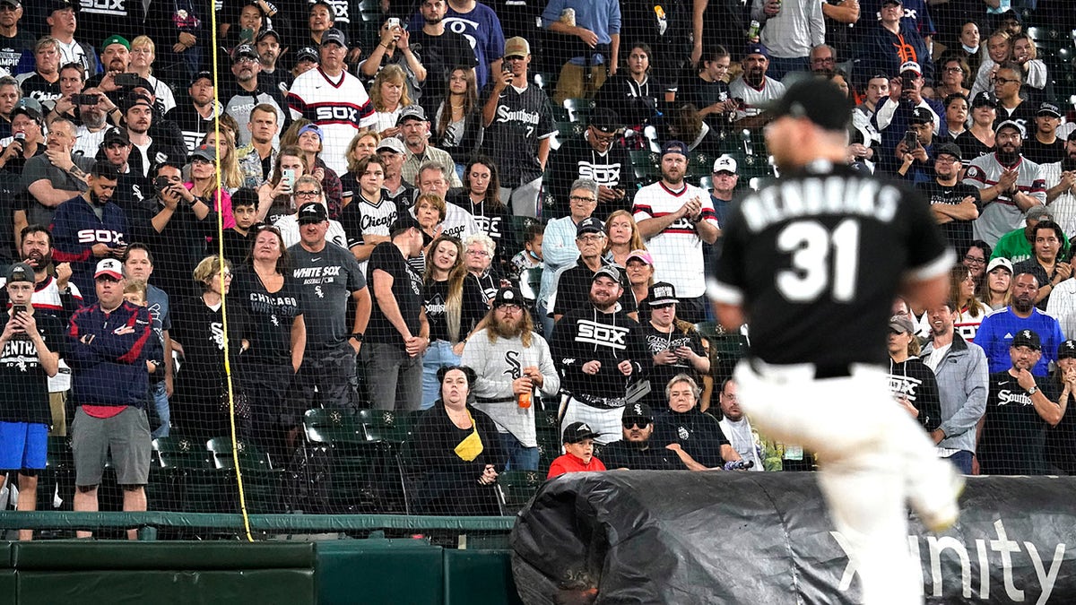 FILE - In this Saturday, Oct. 2, 2021, file photo, fans stand as they watch Chicago White Sox relief pitcher Liam Hendriks work during the ninth inning of a baseball game against the Detroit Tigers in Chicago.