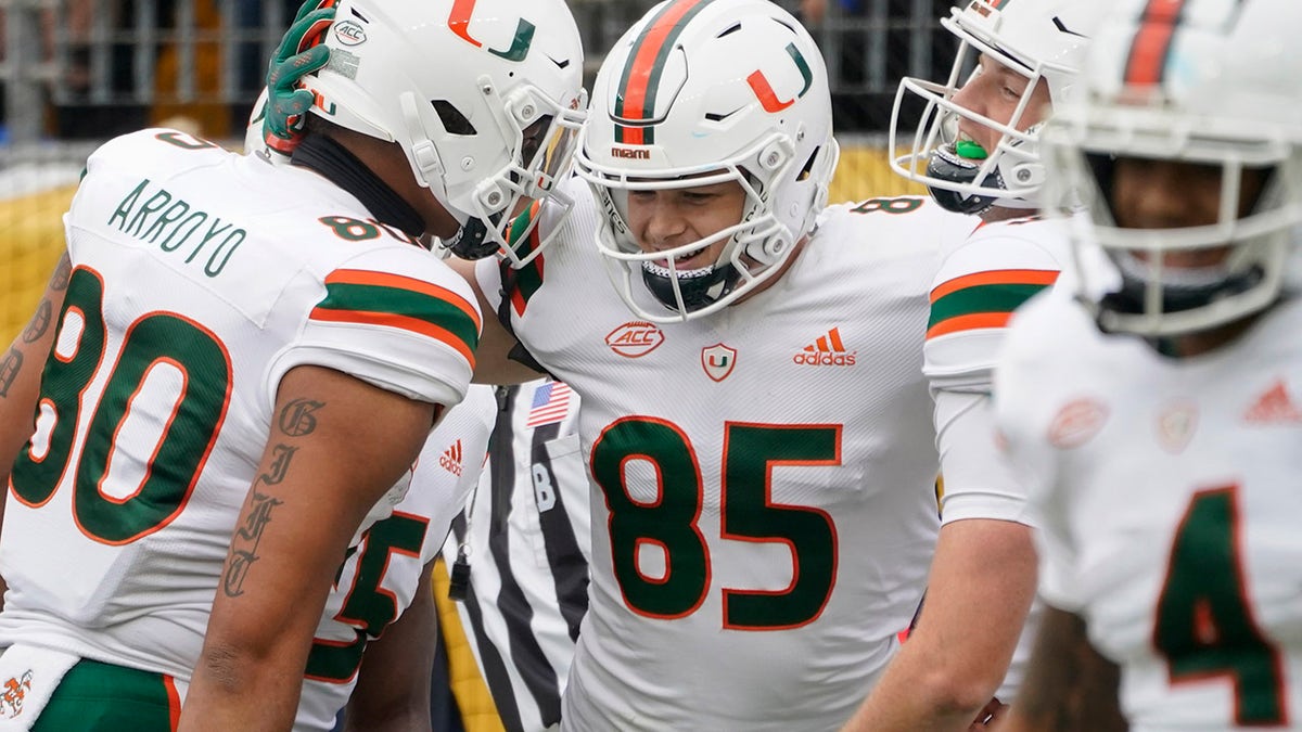 Miami tight end Will Mallory (85) celebrates with Elijah Arroyo (80) and others after making a touchdown catch against Pittsburgh during the first half of an NCAA college football game, Saturday, Oct. 30, 2021, in Pittsburgh.