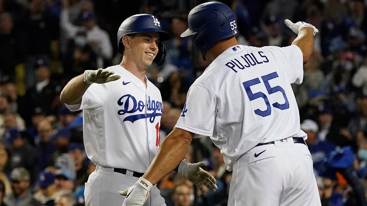 The Los Angeles Dodgers' Will Smith, left, is greeted by Albert Pujols (55) after Smith hit a two-run home run to score Corey Seager during the eighth inning of Game 4 of the National League Division Series against the San Francisco Giants, Tuesday, Oct. 12, 2021, in Los Angeles. The Dodgers won 7-2.