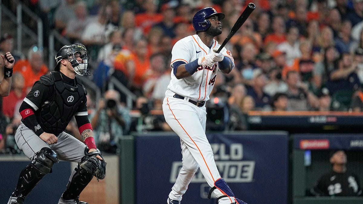 Houston Astros designated hitter Yordan Alvarez watches the ball as he hits a solo home run off Chicago White Sox relief pitcher Reynaldo Lopez during the fifth inning in Game 1 of a baseball American League Division Series Thursday, Oct. 7, 2021, in Houston. White Sox catcher Yasmani Grandal watches the ball as well.