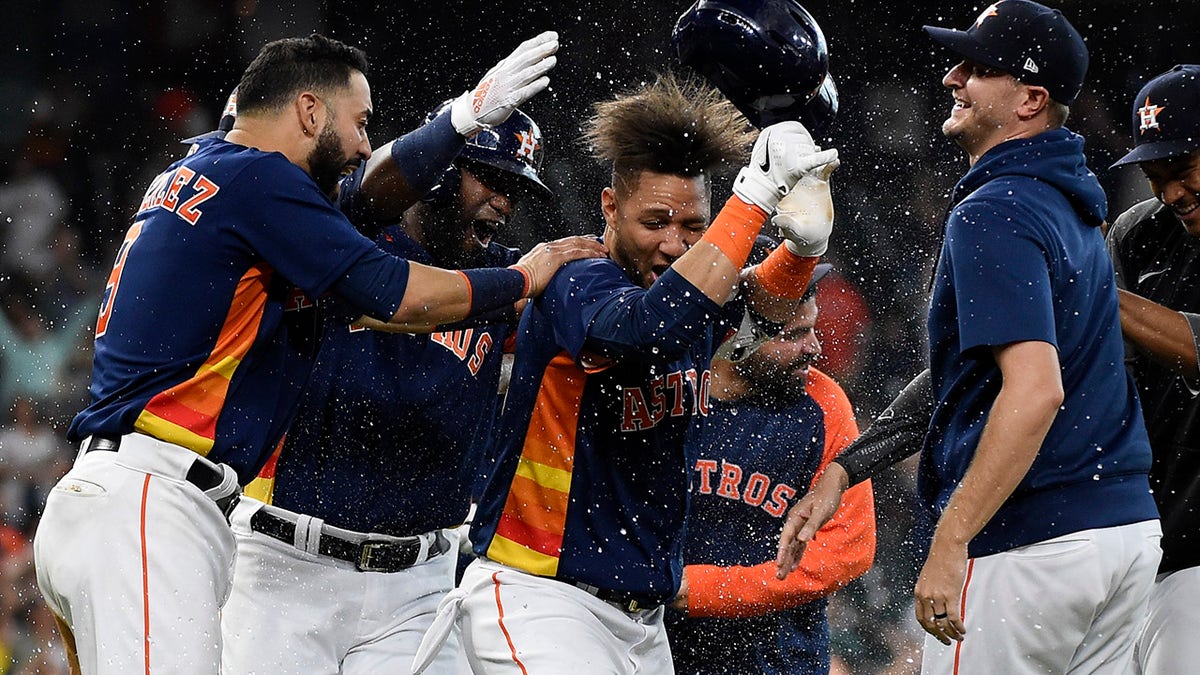 Houston Astros' Yuli Gurriel, center, celebrates his winning hit during the ninth inning of a baseball game against the Oakland Athletics, Sunday, Oct. 3, 2021, in Houston.