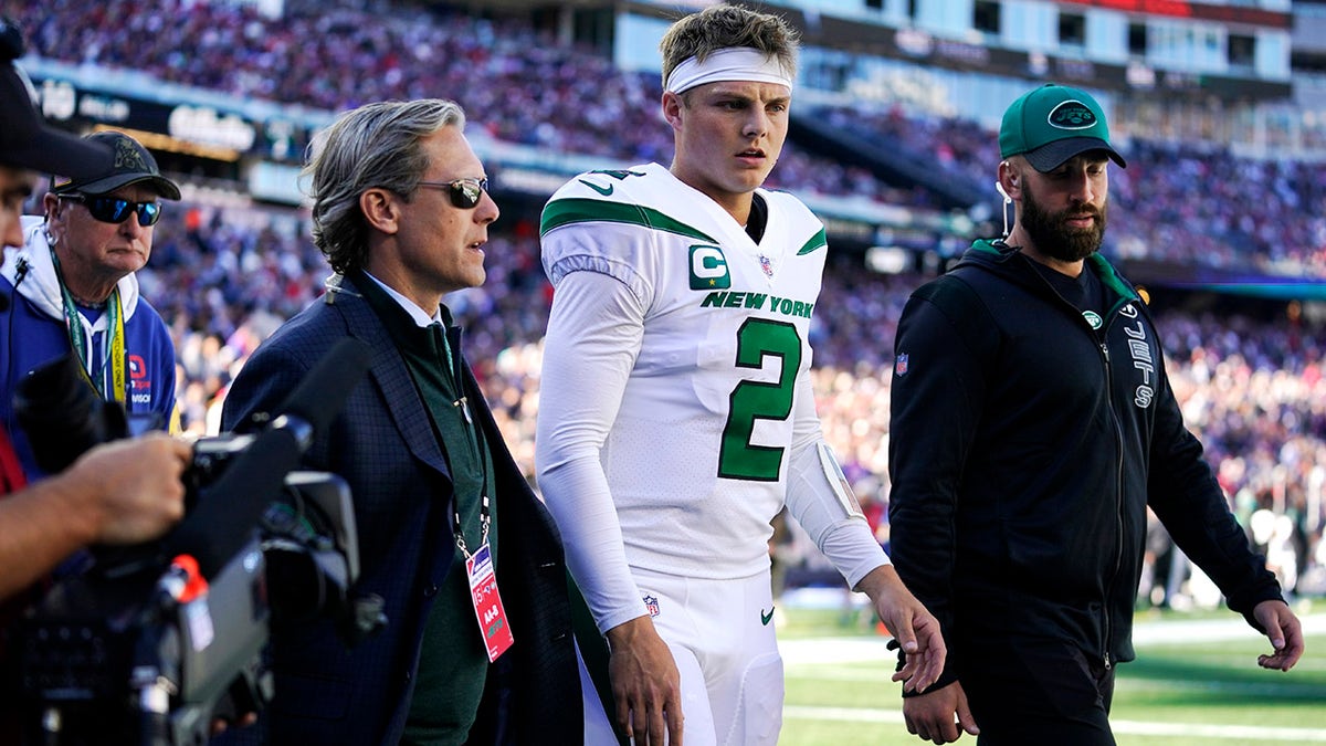 New York Jets quarterback Zach Wilson (2) is escorted to the locker room after an apparent injury during the first half of an NFL football game against the New England Patriots, Sunday, Oct. 24, 2021, in Foxborough, Mass.