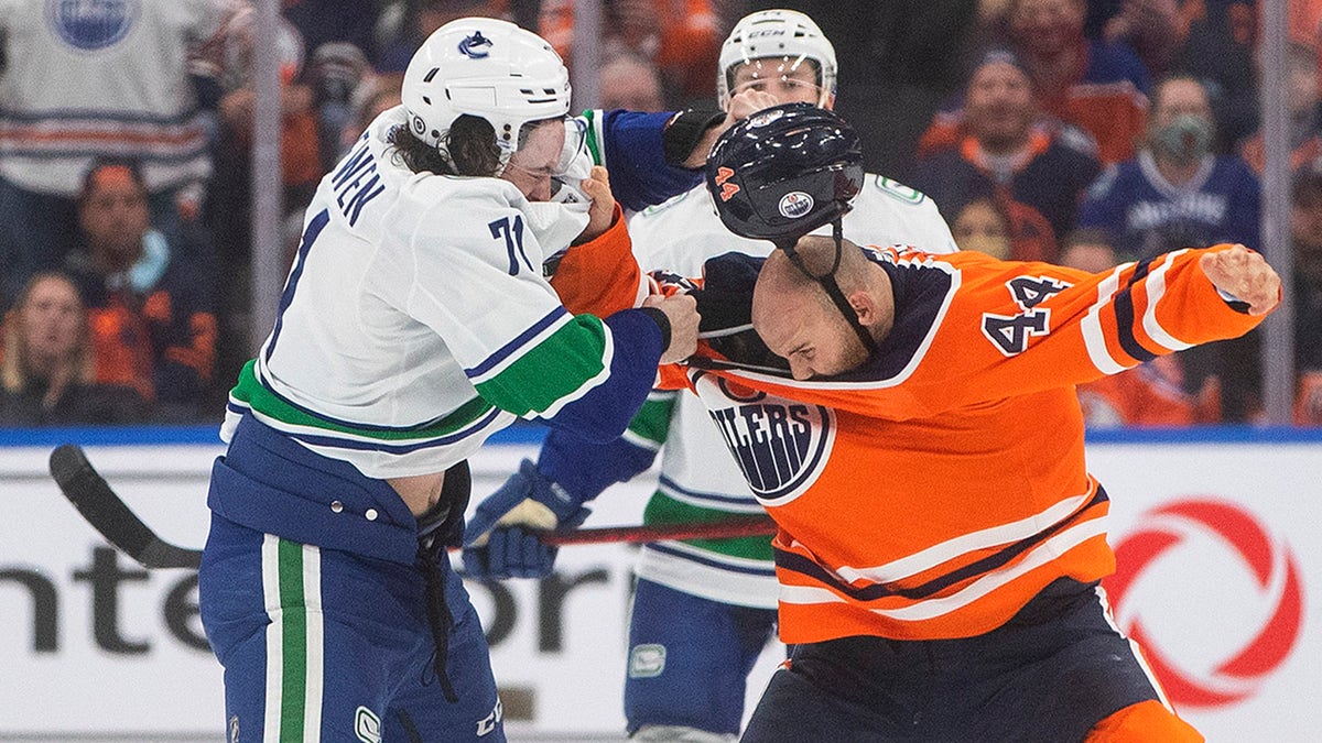 Vancouver Canucks' Zack MacEwen (71) and Edmonton Oilers' Zack Kassian (44) fight during the third period of an NHL hockey preseason game Thursday, Oct. 7, 2021, in Edmonton, Alberta.