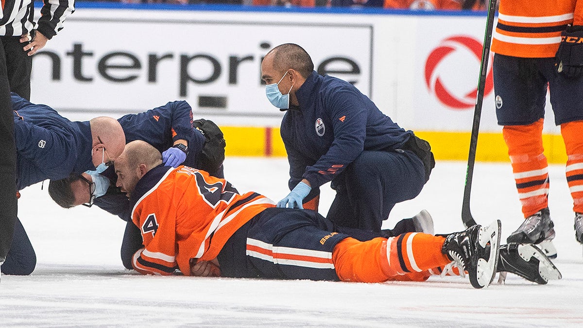 Edmonton Oilers' Zack Kassian (44) is tended to by medical staff after a fight with Vancouver Canucks' Zack MacEwen during the third period of an NHL hockey preseason game Thursday, Oct. 7, 2021, in Edmonton, Alberta.