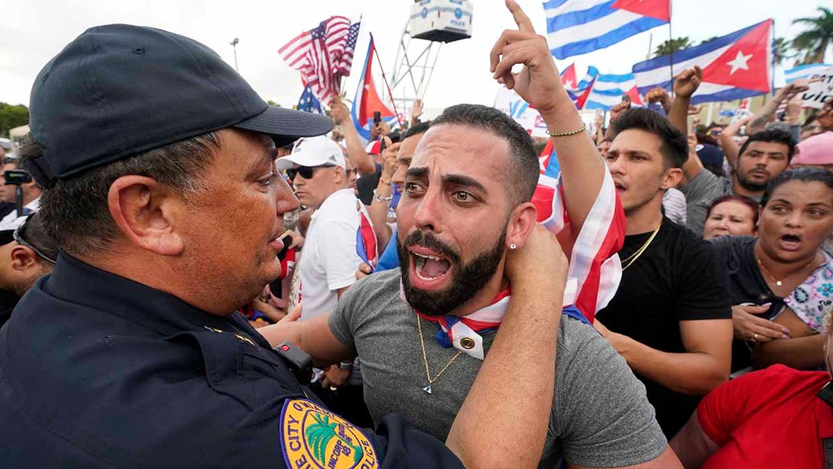 FILE - In this Wednesday, July 14, 2021, file photo, Miami Police Chief Art Acevedo, left, hugs a demonstrator, in Miami's Little Havana neighborhood, as people rallied in support of antigovernment demonstrations in Cuba. City of Miami commissioners held a special meeting in which they attacked Acevedo less than six months into his post, and voted to further investigate him and his appointment. 